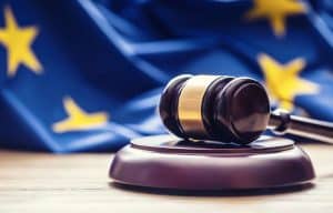 Judges wooden gavel with EU flag in the background. Symbol for jurisdiction.