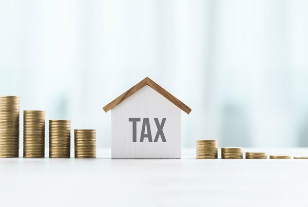 House model and stack of coins representing property, values, and real estate taxes