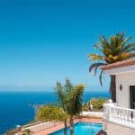 Luxury rental property in Spain with swimming pool, palm trees and ocean sea view