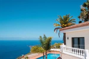 Luxury rental property in Spain with swimming pool, palm trees and ocean sea view