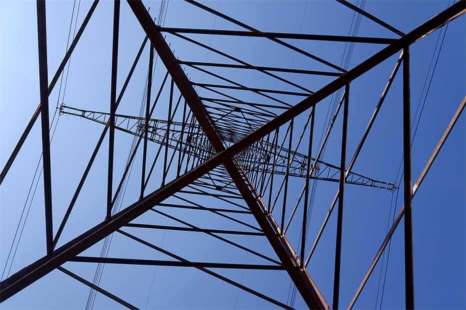 Electricity pylons conducting current from distribution power station, blackout and grid stability concept.